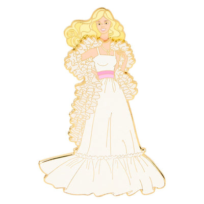 Magnetic pin of Barbie in a white ruffled dress with a pink waistband, long blonde hair, and hands on her hips, celebrating the 65th anniversary.