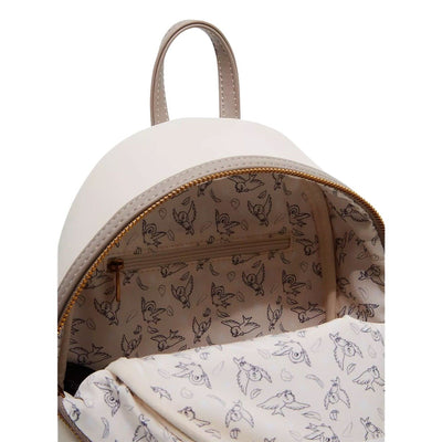 The inside of the backpack, showing a pattern of small birds and leaves on a light background. The interior includes a zipper pocket.