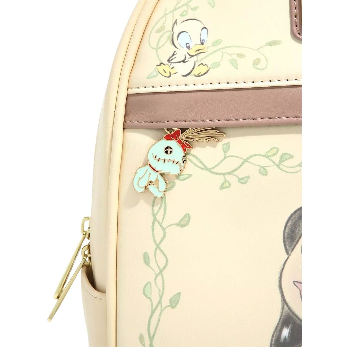 Front pocket close-up: Featuring a small duckling and a charm of a stitched doll with a feather.