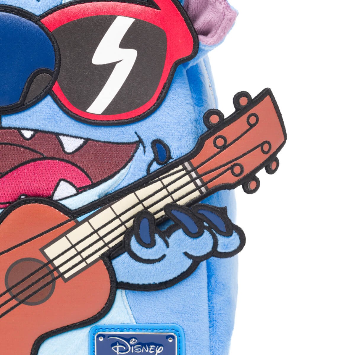 Close-up of Stitch's hand holding the ukulele on the mini backpack.