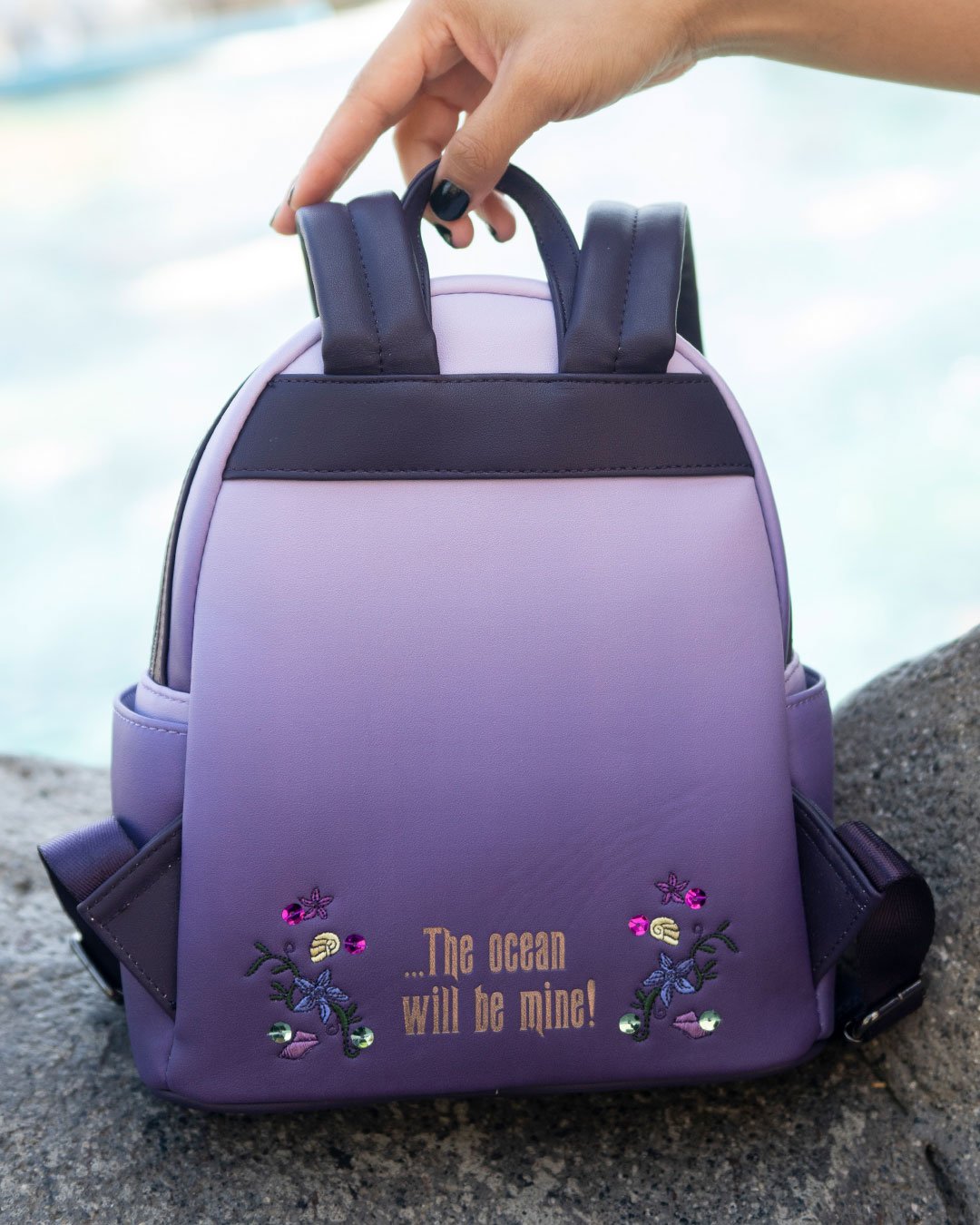 671803390935 - 707 Street Exclusive - Loungefly Disney Villains Scenes Ursula Mini Backpack - Model Holding Loungefly Bag at Disneyland